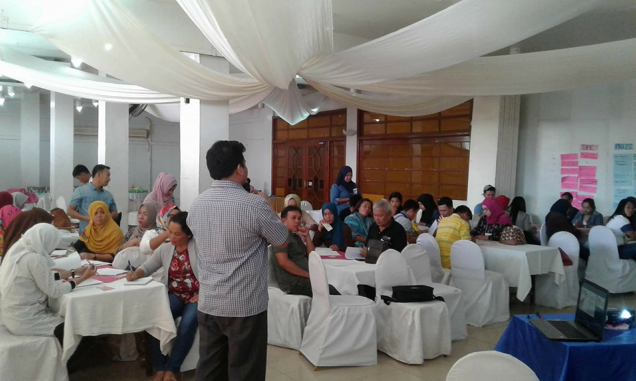 Community facilitators discuss cooperative management together during the IOM–PAMANA orientation.