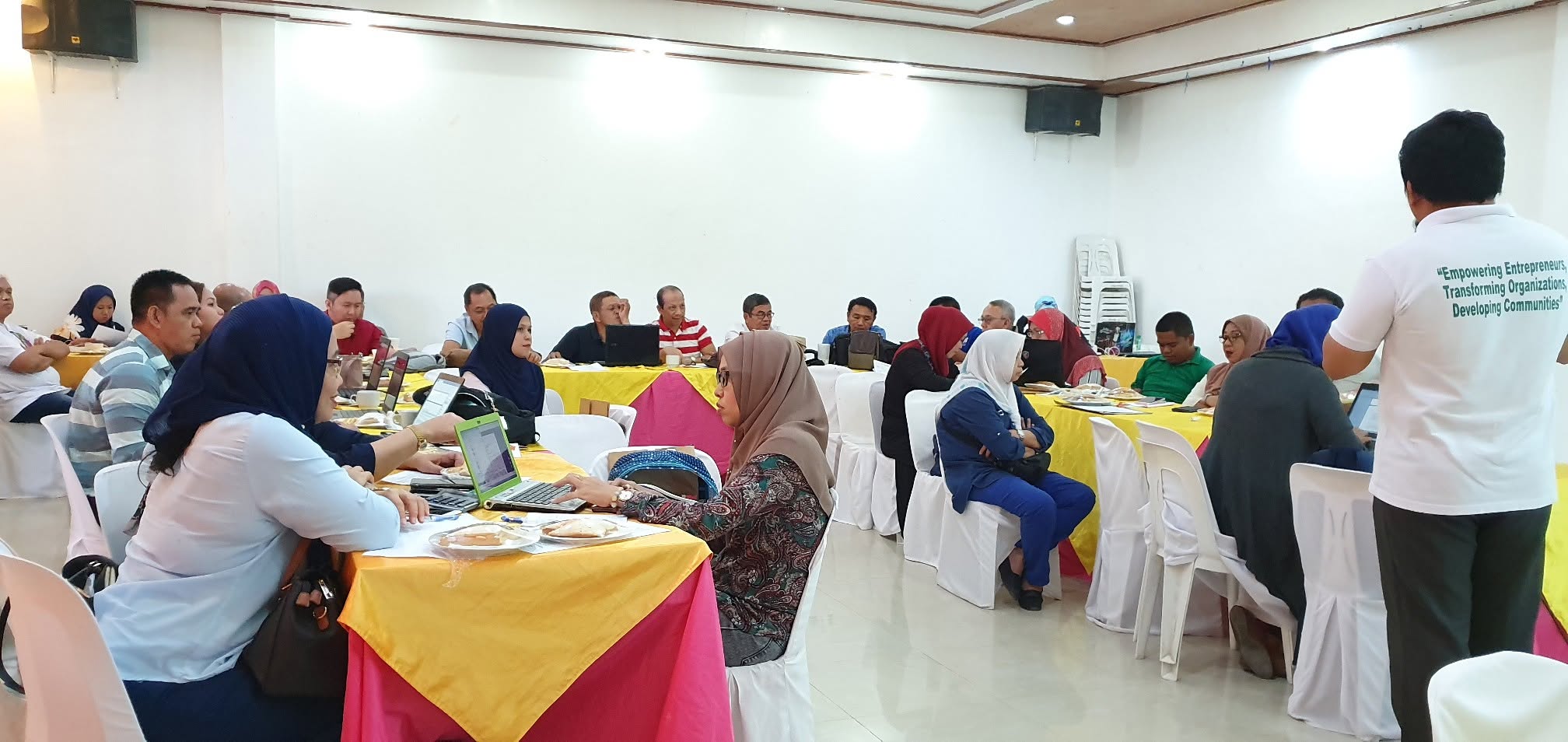 A facilitator leads MTIT's strategic planning workshop as participants work at their tables.