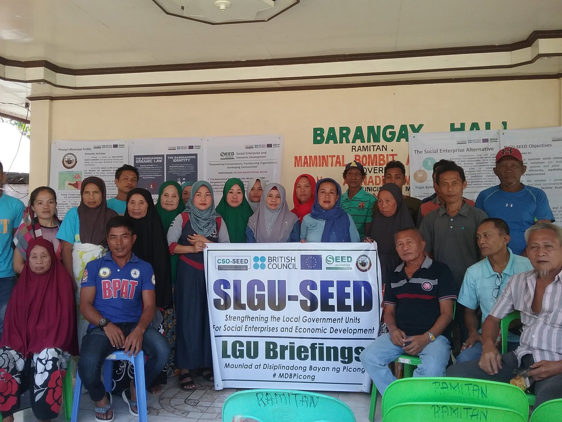 Community participants gather behind the SLGU–SEED local government briefings banner.